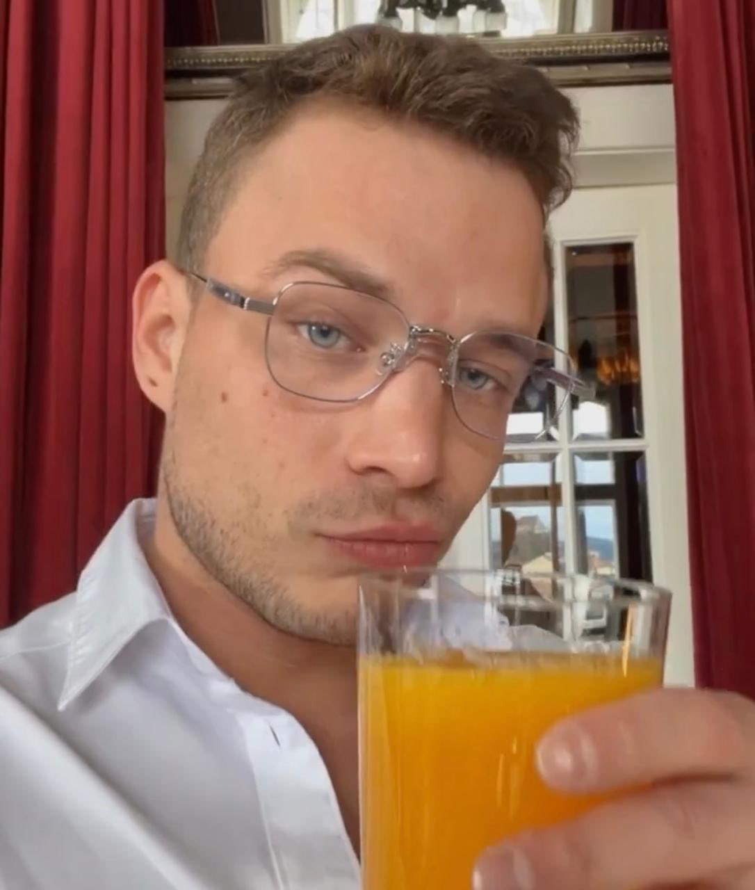 Pavlos holding a glass of orange juice